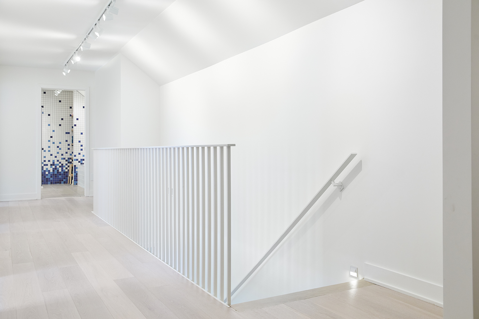 Escalier épuré blanc résidentiel conçu sur mesure par SLIK Entreprise.